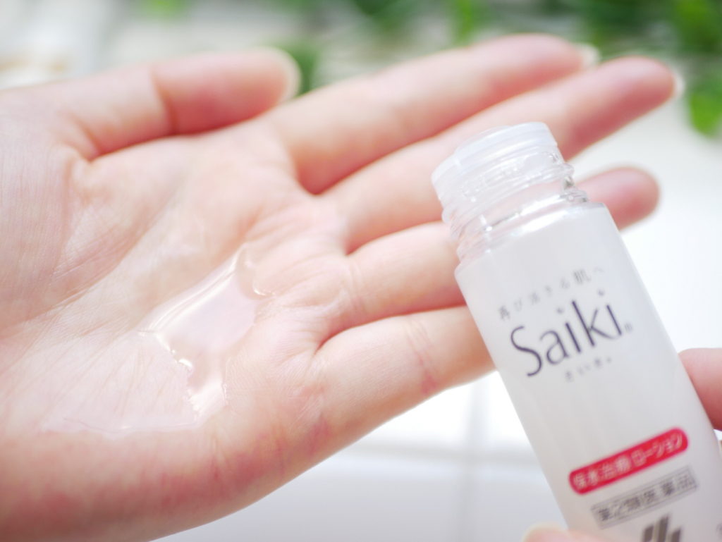 小林製薬さいきa治療ローションを左手にとる